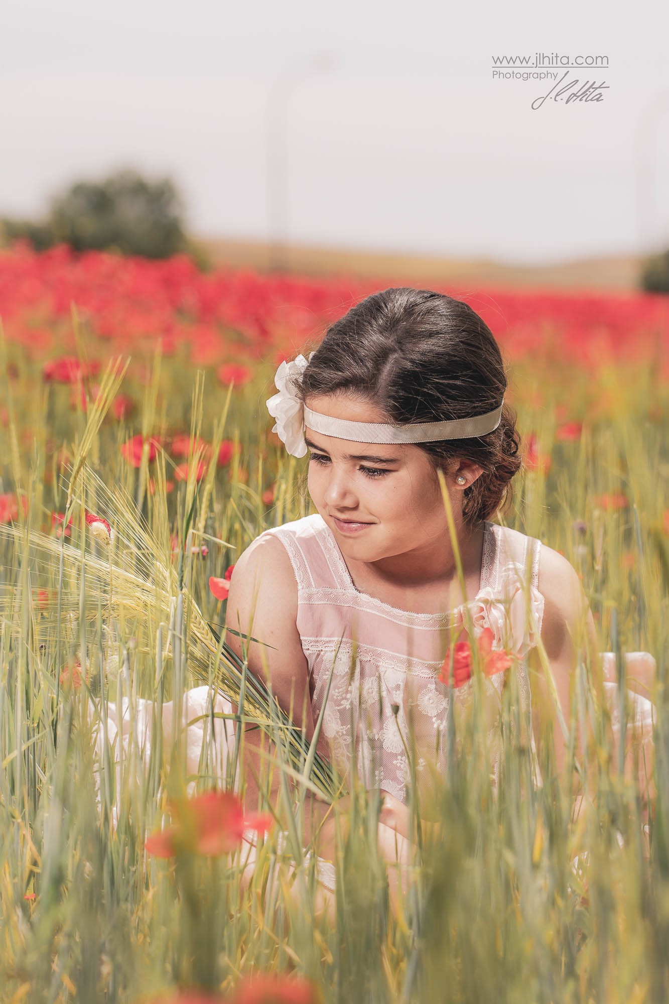 Carlota sentada entre amapolas
