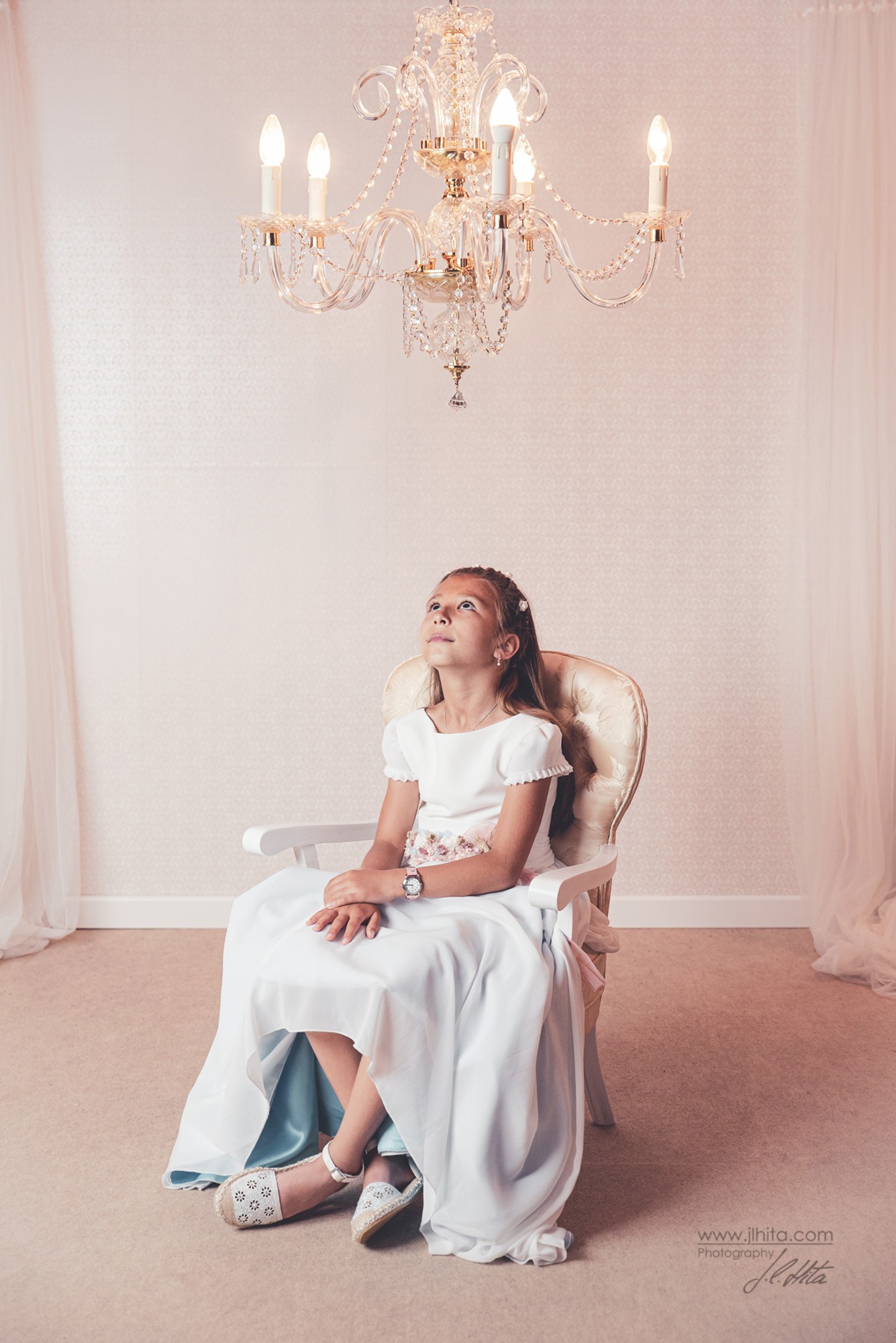 Fotografía de comunión de Paula escena mirando lampara de araña
