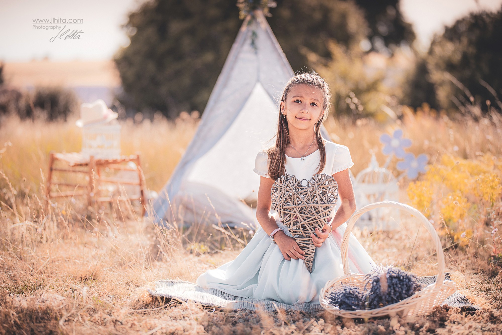 Sesión de comunión de Paula con un tipi y un corazón de mimbre